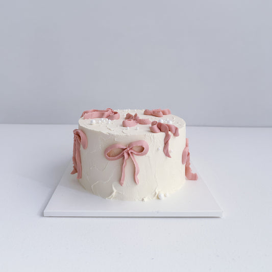 White cake with pink decorations on a white background